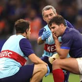 Antoine Dupont is treated by medics after picking up an injury in France's crushing win over Namibia.
