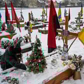 A woman decorates a Christmas tree at the grave of her husband, Oleg Skybyk, a Ukrainian serviceman who was killed resisting the Russian invasion of Ukraine (Picture: Yuriy Dyachyshyn/AFP via Getty Images)