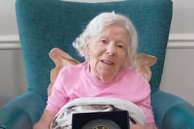Resident at HC-One Scotland’s Highgate Care Home with their gardening plaque