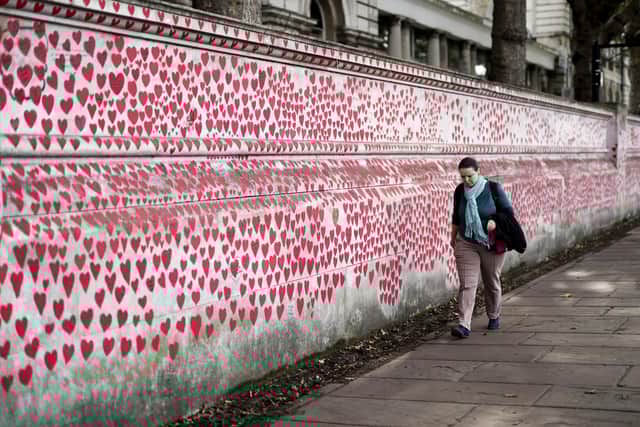 A member of the public observing the National Covid Memorial Wall, a public mural painted by volunteers to commemorate the victims of the COVID-19 pandemic.
