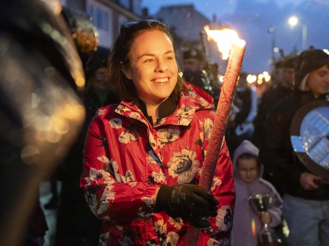 A packed torchlit procession through the streets of Oban, led by Oban Pipe Band, Deputy First Minister Kate Forbes, members of An Comunn Gàidhealach and the local organising committee.  Undeterred by the west coast weather, the Oban community came out in force to witness the spectacle and follow the procession from Station Square, along the esplanade to the event’s flagship event, The Corran Halls.
