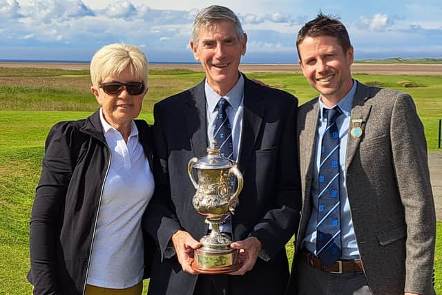 Bob Humble, flanked by ladies' captain Lorraine Tilbrook and club captain Martin Hay, shows off the trophy after winning the Kilspindie club championship for a 22nd time.