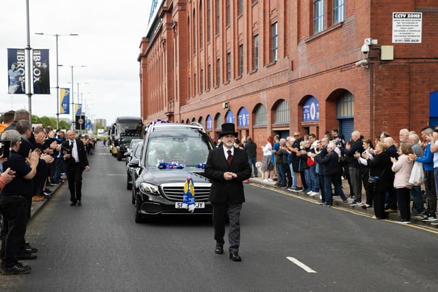 Rangers supporters line the street at Jimmy Bell's funeral cortege passes through Ibrox Stadium.