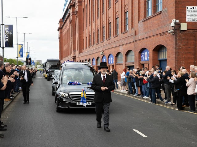 Rangers supporters line the street at Jimmy Bell's funeral cortege passes through Ibrox Stadium.