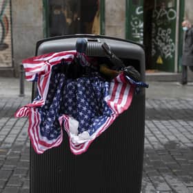 An umbrella in the colours of the US flag lies stuffed in a trash bin in Madrid, Spain. Picture: AP Photo/Paul White