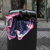 An umbrella in the colours of the US flag lies stuffed in a trash bin in Madrid, Spain. Picture: AP Photo/Paul White