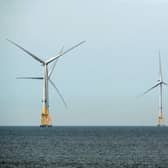 A ferry navigates past wind turbines off the coast of Aberdeen (Picture: Andy Buchanan / AFP)