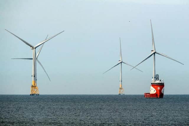 A ferry navigates past wind turbines off the coast of Aberdeen (Picture: Andy Buchanan / AFP)
