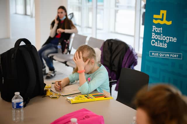 Ukrainian refugee Alisa Koletvinova, aged eight, draws in her colouring book while her parents wait to speak to UK Home Office officials at a port building in Calais, France (Picture: Leon Neal/Getty Images)