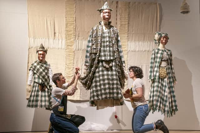 Textile display specialists Gesa Werner and Jessie Staniland put the finishing touches to tartans designed by Olubiyi Thomas during a preview for the forthcoming Tartan exhibition at V&A Dundee. Picture: Jane Barlow/PA Wire