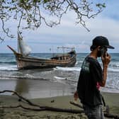 This picture shows a boat that was carrying Rohingya refugees after their arrival at a beach in Krueng Raya, Indonesia's Aceh province on December 25, 2022. (Photo by CHAIDEER MAHYUDDIN/AFP via Getty Images)