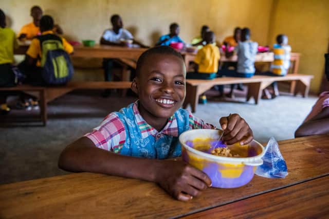 Boy in Liberia receiving Mary's Meals (Photo: Chris Watt Photography).