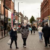 Shoppers, wearing facemasks because of the novel coronavirus pandemic, walk in the High Street of Leigh, Greater Manchester, northwest England on October 22, 2020, as new restrictions meant to contain surging cases of Covid-19 are imposed on Greater Manchester. - Britain's Prime Minister Boris Johnson's government unilaterally imposed the rules on Greater Manchester after failing to reach a funding deal with its mayor Andy Burnham, a former Labour MP for Leigh. But locals say widespread confusion and fatigue with Britain's Covid-19 response risk undermining the government's latest plans. (Photo by OLI SCARFF / AFP) / To go with AFP story by James PHEBY (Photo by OLI SCARFF/AFP via Getty Images)