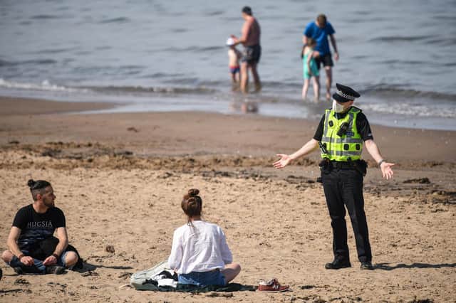 Police speaking to sunbathers on Portobello beach in Edinburgh on Wednesday. Picture: Jeff J Mitchell.