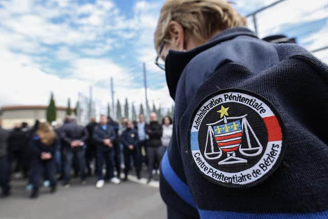 Prison officers gather and block the entrance of the jail during a protest in Beziers, south of France. French police are hunting for a group of gunmen who killed two prison officers and wounded three others, in an attack of a prison van transporting an inmate at a motorway toll in Incarville, northern France. Picture: Pascal Guyot/AFP via Getty Images