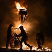 The Clavie, a burning barrel packed with tar soaked sticks fixed on the top of a pole, is surrounded by Clavie Crew at the Doorie Hill in Burghead.
