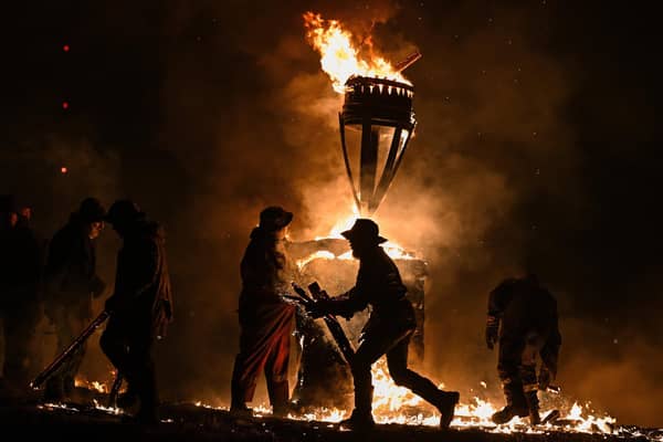 The Clavie, a burning barrel packed with tar soaked sticks fixed on the top of a pole, is surrounded by Clavie Crew at the Doorie Hill in Burghead.