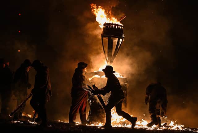 The Clavie, a burning barrel packed with tar soaked sticks fixed on the top of a pole, is surrounded by Clavie Crew at the Doorie Hill in Burghead.