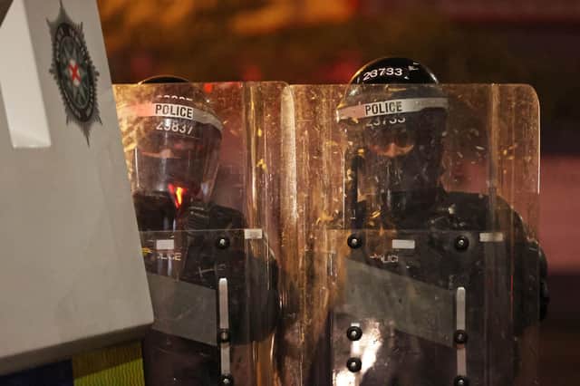 PSNI officers stand behind a Land Rovers on the nationalist side of the Springfield Road in Belfast after dispersing people from the area, following further unrest. Picture: Liam McBurney/PA Wire