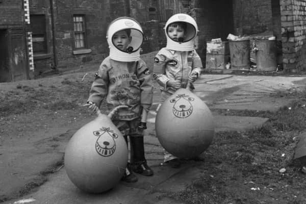 Little boys show off their Xmas presents (including astronaut suits and Space Hoppers) in Crown Street in the Gorbals area of Glasgow in December 1970.