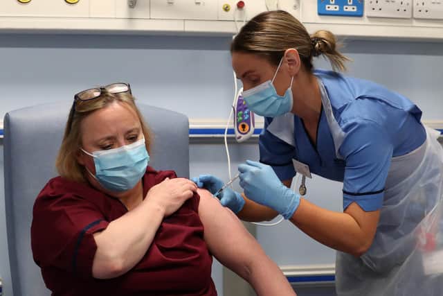 Deputy charge nurse Katie McIntosh administers the first of two Pfizer/BioNTech Covid-19 vaccine jabs to Vivien McKay, Clinical Nurse Manager at the Western General Hospital in Edinburgh on Tuesday.
