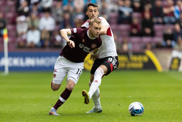 Hearts' Nathaniel Atkinson skips by Aberdeen's Bojan Miovski during Saturday's match at Tynecastle. (Photo by Ross Parker / SNS Group)