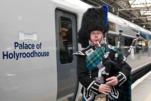 Border Piper Sandy Mutch beside the train at Edinburgh Waverley Station. Picture: TransPennine Express