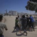 Palestinians rush to collect humanitarian aid airdropped by parachutes into Deir al-Balah, central Gaza Strip, Tuesday, Aug. 5, 2025. (AP Photo/Abdel Kareem Hana)