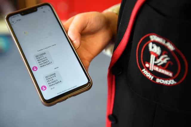 A pupil at Stonlelaw High School in Rutherglen, Glasgow, receives a text message with her exam grades on her mobile phone last year.