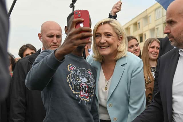 Marine Le Pen poses for a picture with a man during her visit in the coastal city of Berck