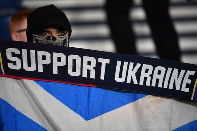 A Scotland fan shows support for Ukraine ahead of the friendly football match between Scotland and Poland  (Photo by ANDY BUCHANAN/AFP via Getty Images)