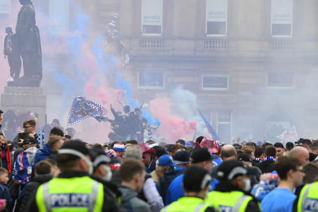 Police officers monitor as Rangers fans celebrate in George Square in Glasgow on May 15