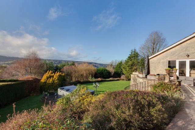 The rear garden is mainly laid to lawn and includes a timber decked seating terrace with combination hot tub/swim spa. The garden slopes down to woodland.