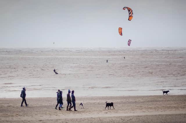 Walkers and kite surfers on Exmouth Beach despite the Government advising the public to reduce social interaction due to the coronovirus outbreak.  Picture: Victoria Jones/PA Wire