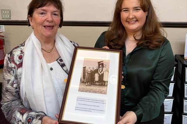 Dumfries Academy history teacher Heather Chalk and Deirdre McDowell holding a photograph of Jane Haining and family.