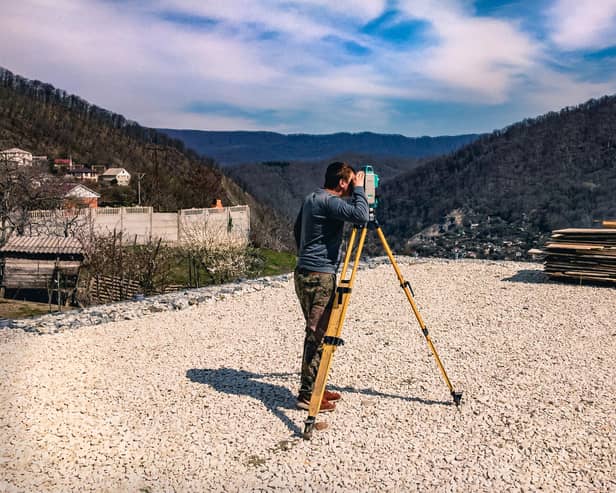A surveyor looks out over geological formations as part of research work.