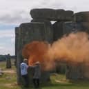 Just Stop Oil activists spray orange powder paint on the 4,500-year-old stone circle at Stonehenge (Image: Still from Just Stop Oil's video)