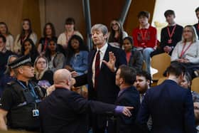 Police and security staff deal with a protester in the public gallery during First Minister's Questions at Scottish Parliament (Picture: Jeff J Mitchell/Getty Images)
