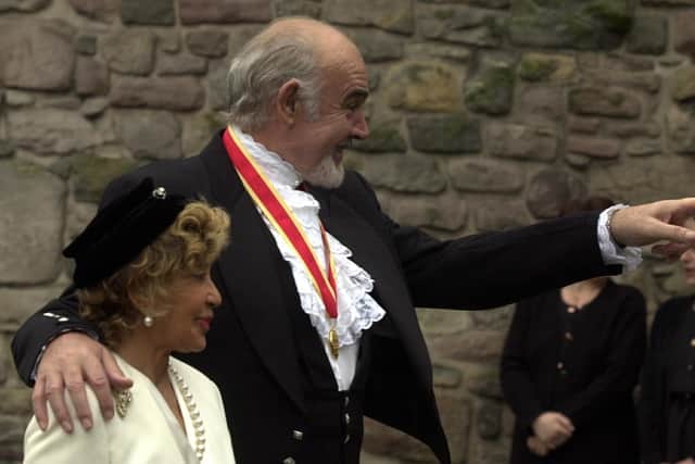 Sir Sean Connery  accompanied by his wife, Micheline points at someone in the crowd after receiving his Knighthood from HM The Queen at The Palace of Holyroodhouse. Pic Neil Hanna