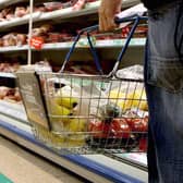 A person holding a shopping basket in a supermarket. The Government is facing a backlash from retailers over its plans to encourage supermarkets to impose voluntary price caps on food staples to help with the cost of living. Picture: Julien Behal/PA Wire