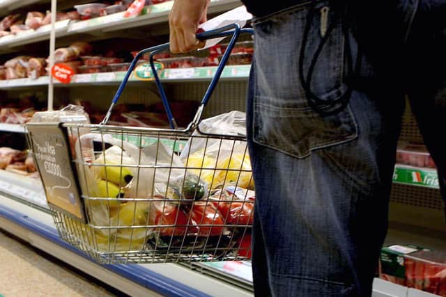 A person holding a shopping basket in a supermarket. The Government is facing a backlash from retailers over its plans to encourage supermarkets to impose voluntary price caps on food staples to help with the cost of living. Picture: Julien Behal/PA Wire