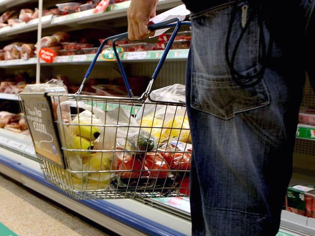 A person holding a shopping basket in a supermarket. The Government is facing a backlash from retailers over its plans to encourage supermarkets to impose voluntary price caps on food staples to help with the cost of living. Picture: Julien Behal/PA Wire