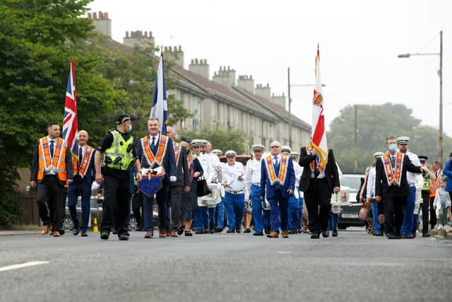 A silent Orange Order band marches through the streets of Easterhouse in Glasgow.
