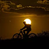 A cyclist tops a hill on a hot day at sunset. The UN weather agency says Earth sweltered through the hottest summer ever as record heat in August capped a brutal, deadly three months in northern hemisphere. Picture: AP Photo/Eric Gay