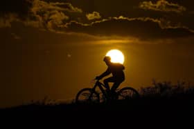 A cyclist tops a hill on a hot day at sunset. The UN weather agency says Earth sweltered through the hottest summer ever as record heat in August capped a brutal, deadly three months in northern hemisphere. Picture: AP Photo/Eric Gay