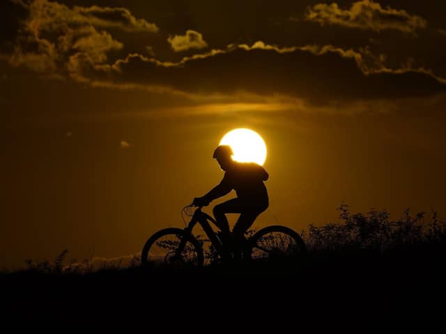 A cyclist tops a hill on a hot day at sunset. The UN weather agency says Earth sweltered through the hottest summer ever as record heat in August capped a brutal, deadly three months in northern hemisphere. Picture: AP Photo/Eric Gay