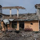 A soldier looks at a school that was destroyed during fighting between Ukrainian and Russian occupying forces