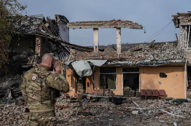 A soldier looks at a school that was destroyed during fighting between Ukrainian and Russian occupying forces