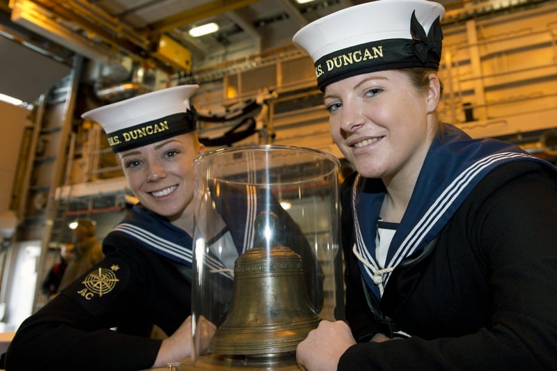 2013. Able Seaman Fiona MacLennan (L) and Able Seaman Megan Ryan (R) pose for a photograph beside the original bell of the 16th century Tudor warship Mary Rose aboard HMS Duncan, the latest Type 45 destroyer, ahead of the public opening of the new Mary Rose Museum in Portsmouth, southern England on May 30, 2013. Picture: ADRIAN DENNIS/AFP via Getty Images