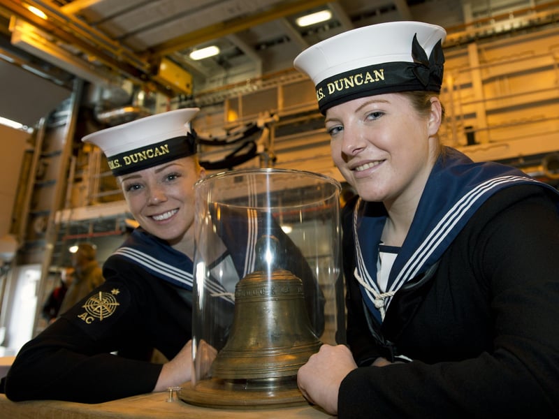 2013. Able Seaman Fiona MacLennan (L) and Able Seaman Megan Ryan (R) pose for a photograph beside the original bell of the 16th century Tudor warship Mary Rose aboard HMS Duncan, the latest Type 45 destroyer, ahead of the public opening of the new Mary Rose Museum in Portsmouth, southern England on May 30, 2013. Picture: ADRIAN DENNIS/AFP via Getty Images